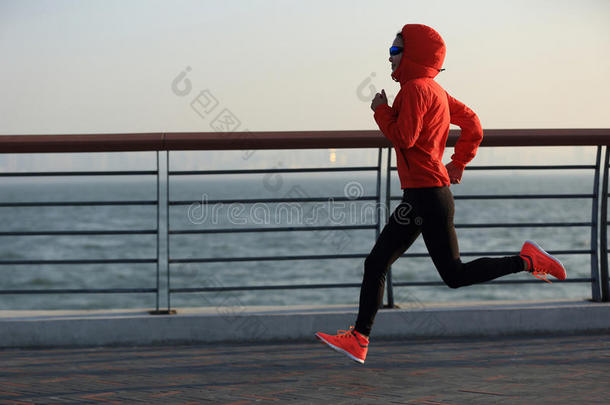 健身女子跑步运动员在海边公路跑步