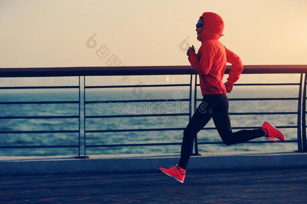 健身女子跑步者在海边跑步