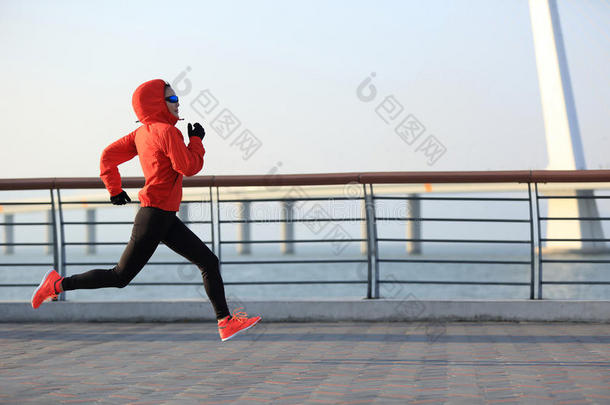 健身女跑步者在海边路上跑步