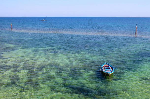 五颜六色的渔船在晶莹剔透的海面上，清澈的沙底和清澈的地平线。