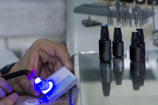 牙科技师在牙齿中使用牙科治疗光。