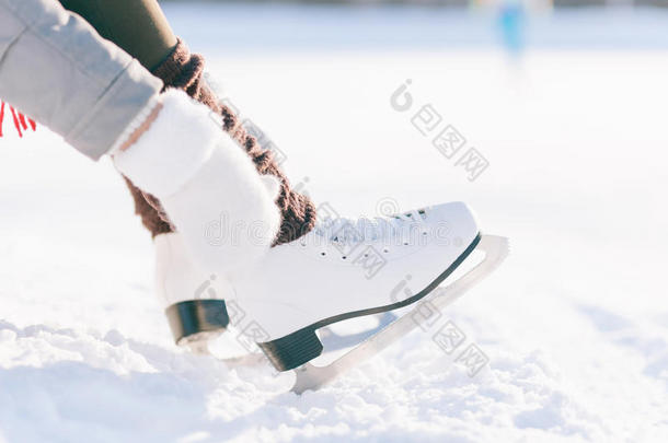 穿裙子的女孩溜冰手套系鞋带