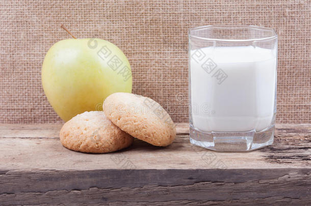 木板上的一杯牛奶、苹果和饼干