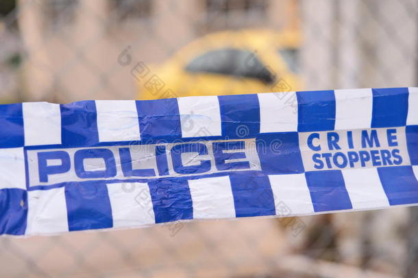 蓝色和白色的警察磁带，用黄色的汽车在一个工业区，澳大利亚，2016年