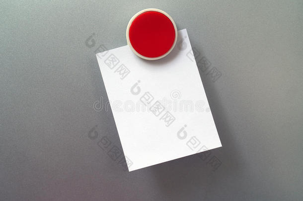 圆形红色塑料冰箱磁铁与空白白色便条纸在灰色金属冰箱门背景
