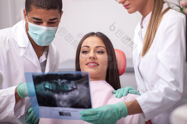 牙医向他的病人解释X光照片的细节
