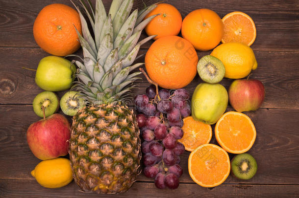 水果背景与橙色，猕猴桃，葡萄，苹果和柠檬在木桌上