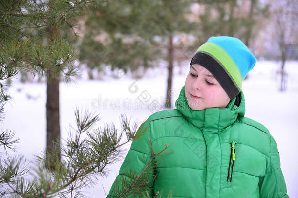冬天<strong>松林</strong>里穿着<strong>绿色</strong>夹克的男孩少年
