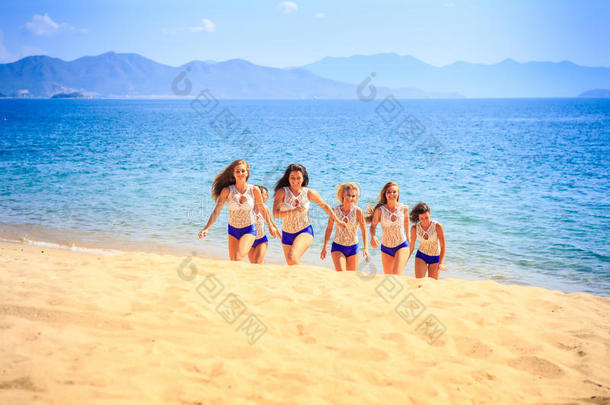 穿着白色蓝色台阶的拉拉队员在海滩上微笑