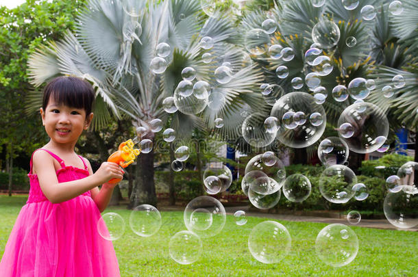 亚洲的中国小女孩从泡泡鼓风机里吹泡泡