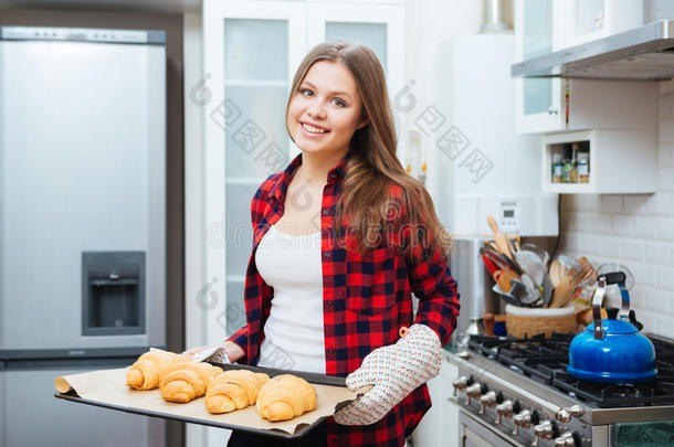 欢快的女人拿着<strong>一盘新鲜</strong>的自制牛角面包