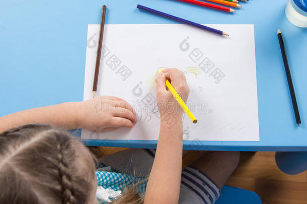 五岁的女孩在纸上画铅笔，俯视