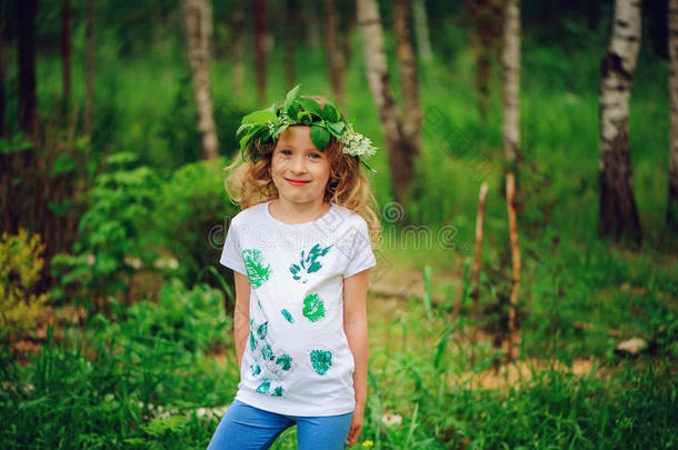 夏天森林里的女孩。 与孩子一起制作自然工艺品的想法-树叶印花衬衫和自然花环。