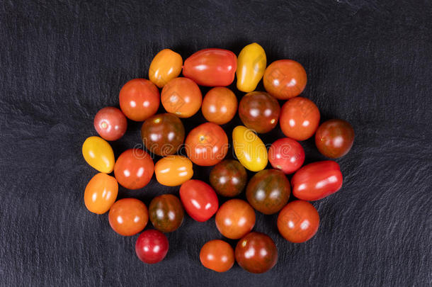 五颜六色的混合小西红柿在天然黑色石板石上