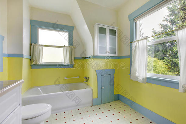 <strong>浴室</strong>有黄色的墙壁，白色的瓷砖地板，和完整的浴缸。
