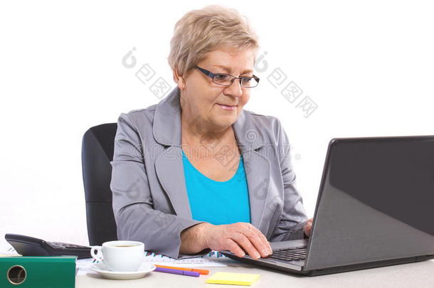 老年商务<strong>妇女</strong>在<strong>办公</strong>室的<strong>办公</strong>桌上用笔记本电脑工作，商业理念