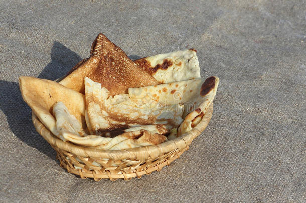 在木制篮子里烤薄饼，在棕色的餐巾纸上抵御雪
