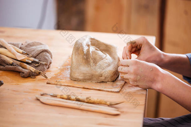 在车间用粘土完成雕塑的完成雕塑的手