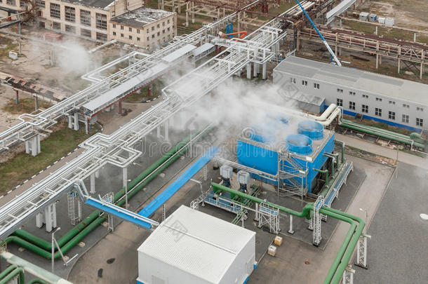 化工厂的蓝色工业冷却塔。 压缩机站和管道。 上面的风景。 我们在冷却塔上