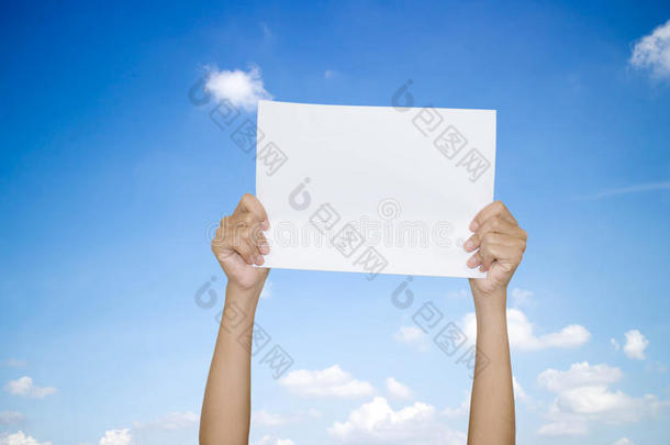 双手拿着纸在天空上。
