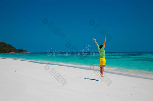 自由海滩暑假概念。 英俊的年轻人跳跃