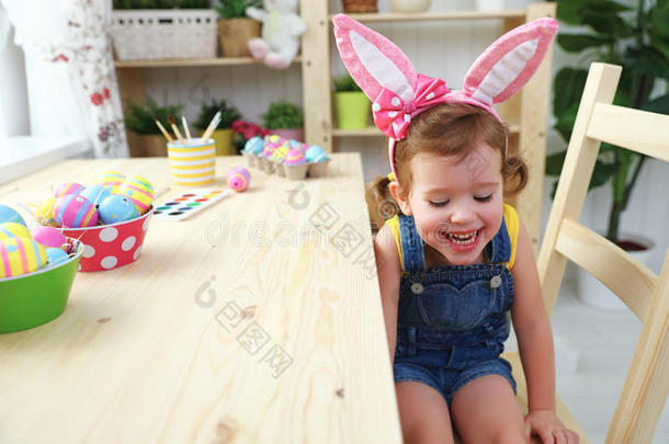 复活节。 快乐的小女孩，兔子耳朵，彩色鸡蛋和f