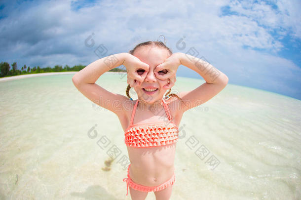 可爱的小女孩在暑假期间像超级英雄一样在海滩玩