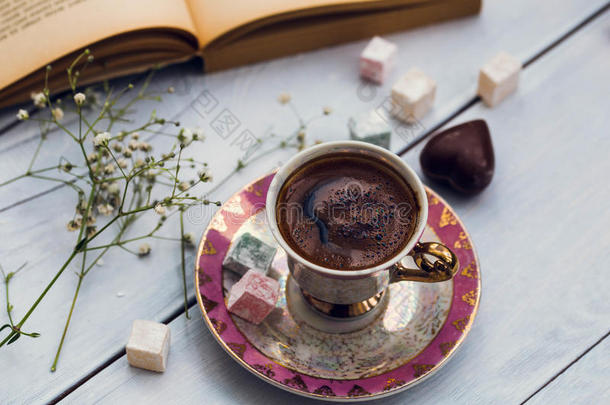 一杯土耳其咖啡，在旧书旁边放着土耳其的快乐和心形巧克力