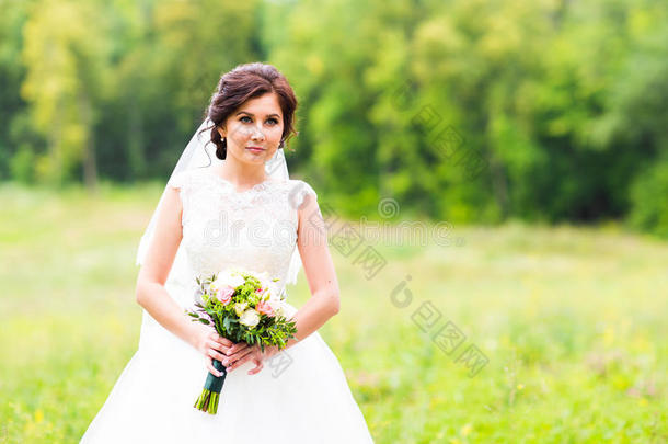 美丽的新娘穿着<strong>婚纱</strong>，带着花束和蕾丝面纱。 穿着白色<strong>婚纱</strong>的漂亮模特女孩