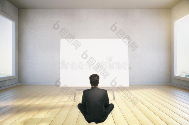 一个人坐在地板上，看着空白的海报，模拟，3D渲染