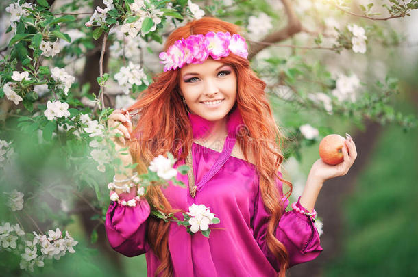 女孩女人红发在开花的春天花园苹果