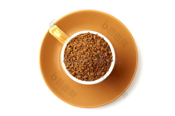 棕色优雅的杯子里装满了速溶咖啡颗粒，碟子下面。 从上面看，所以它是完美的圆形。