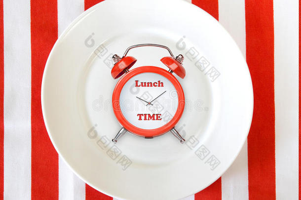 白色平板上的闹钟。午餐时间概念背景