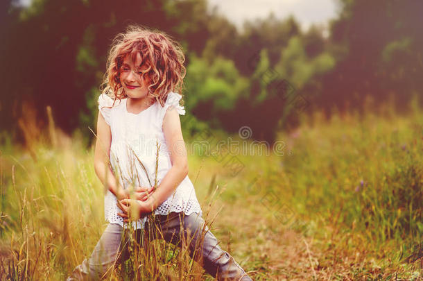 小女孩在夏天的森林里玩树叶。 和孩子们一起探索自然