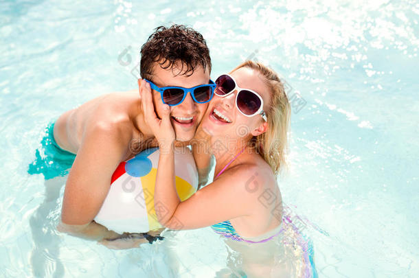 在游泳池里带太阳镜的夫妇。 夏天，太阳，水。