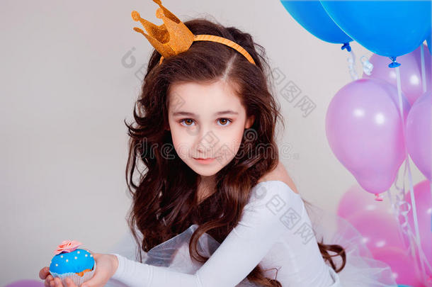 可爱的小公主女孩<strong>坐</strong>在白色背景的房间里的<strong>气球</strong>里。 看着摄像机。 童年。