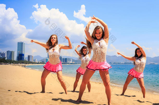 跳舞的啦啦队员们在海滩上向大海摆<strong>手姿势</strong>