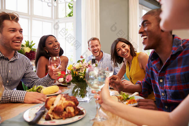在家的朋友围坐在桌子旁参加晚宴