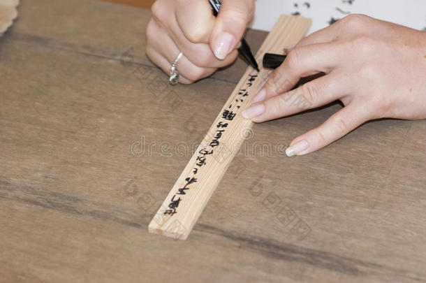女孩的手在祈祷板上用日语写个人愿望
