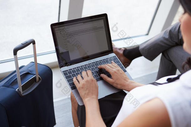 女商人在机场候机厅使用笔记本电脑