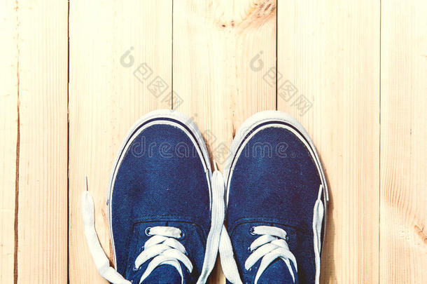蓝色运动鞋在木制背景与复制空间。 上面的风景。