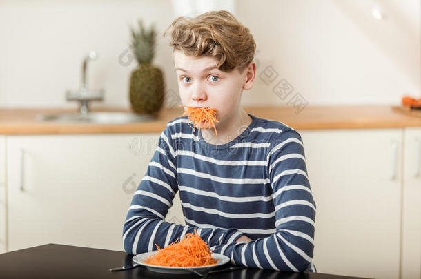 男孩在桌子上吃着一口胡<strong>萝卜丝</strong>