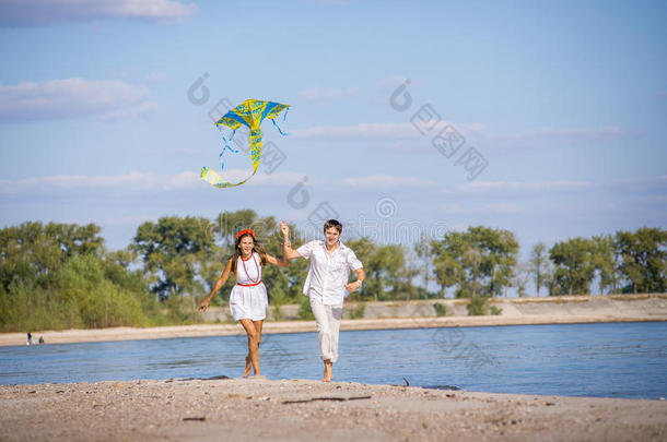 女孩和一个男人在春天，夏天在海滩上放风筝。