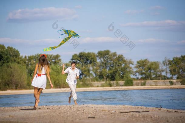 女孩和一个男人在春天，夏天在海滩上放风筝。