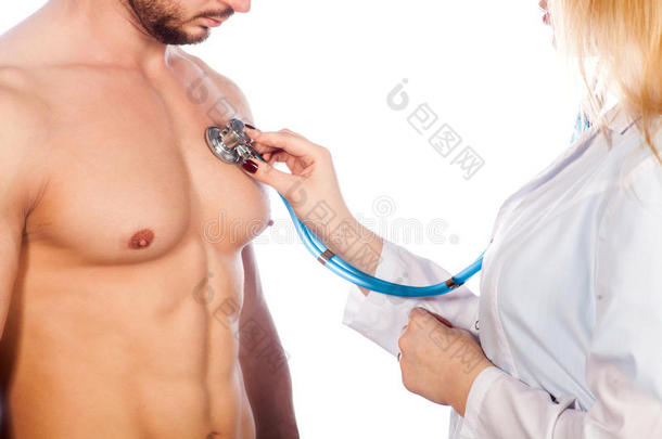 医生在医院的办公室里用听诊器听年轻病人的胸部。