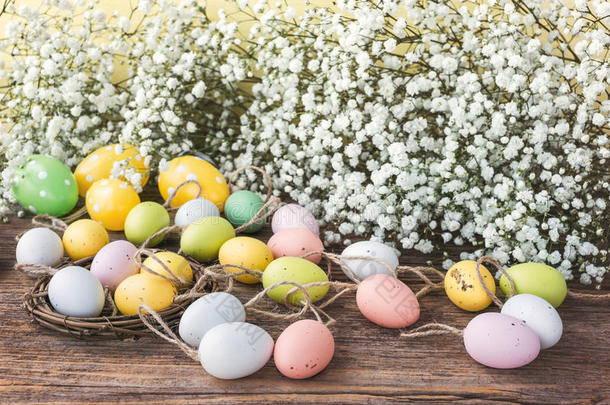 复活节背景，装饰彩色鸡蛋和白色花。 色调