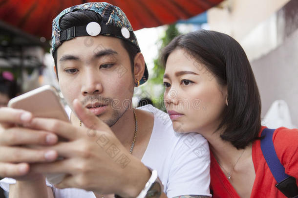 亚洲年轻的男人和女人在智能手机上观看人们和数字技术、<strong>wifi</strong>和互联网连接