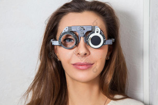 漂亮的女孩用矫正镜片检查眼科医生的视力