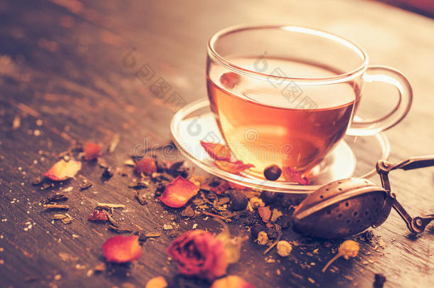 玻璃茶杯与干玫瑰花蕾