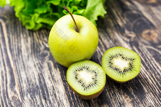 木制背景上的新<strong>鲜猕猴桃</strong>、苹果和杏仁。 健康生活方式的概念
